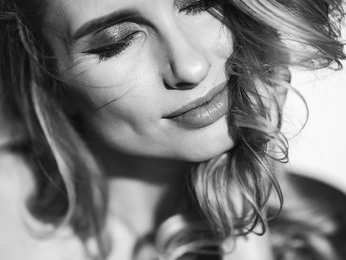 Black and white close-up image of woman with light hair.