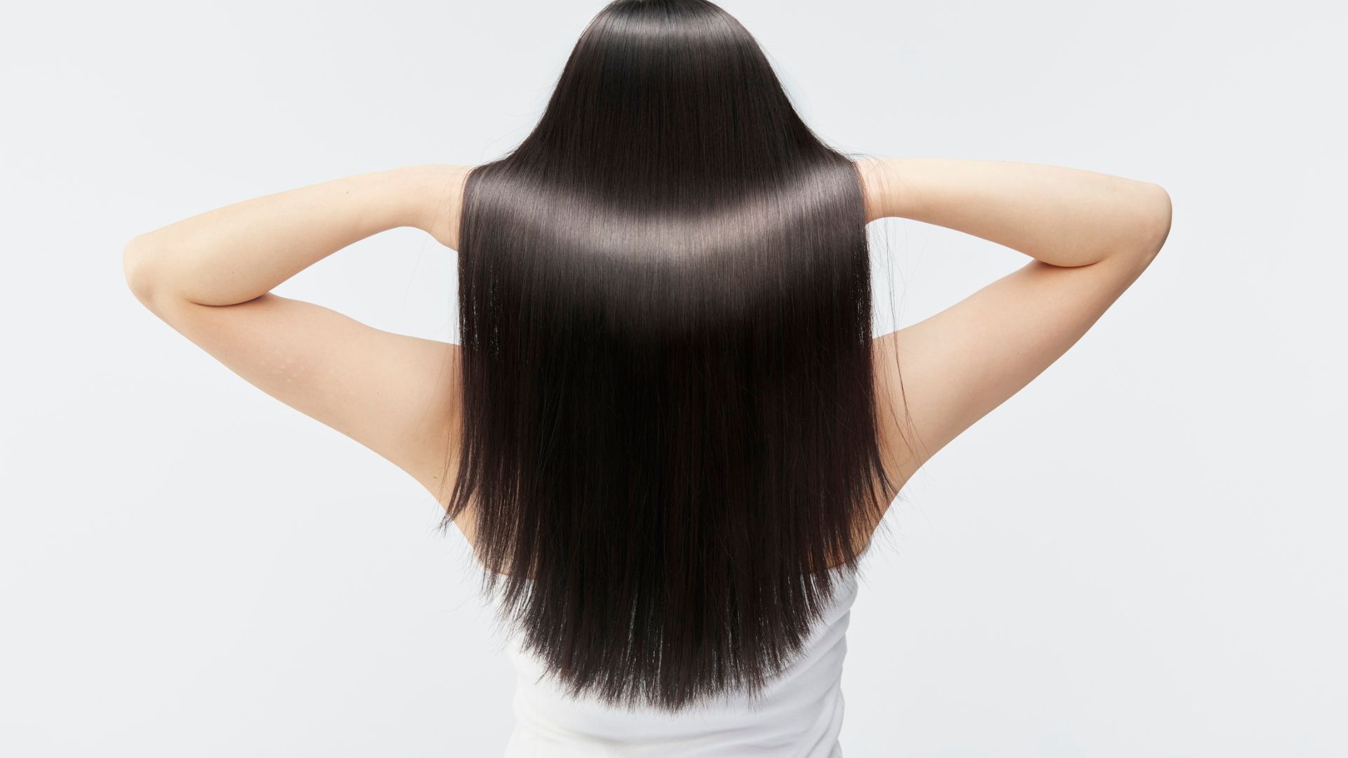 a woman lifting her long black hair
