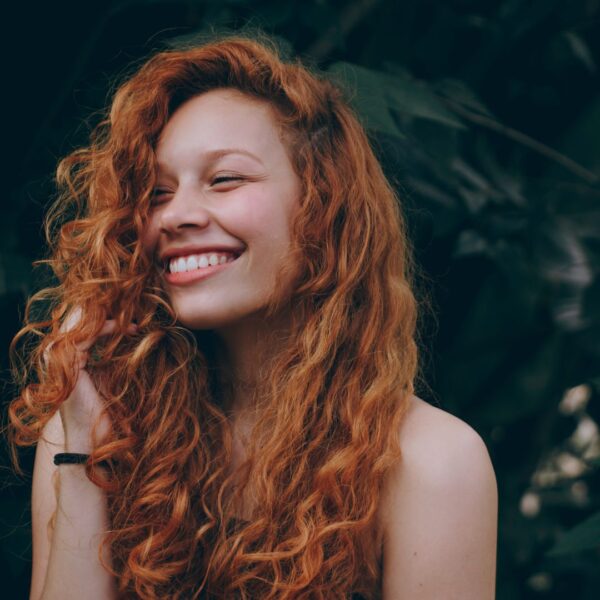 a woman with long curly hair smiling