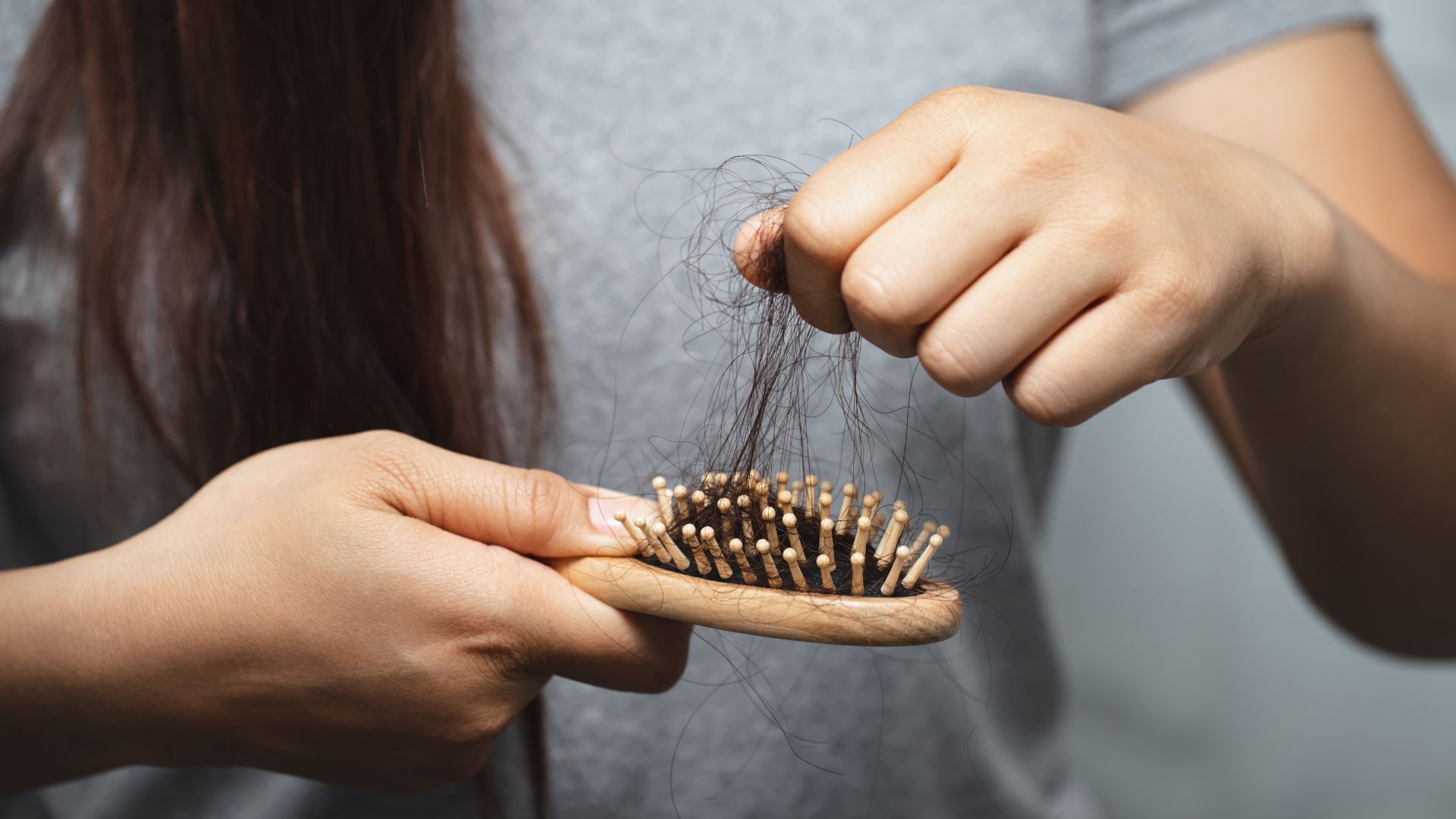 a person removing hair from a hair brush